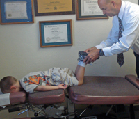 Dr. Whitemyer checking the leg length of a young patient.