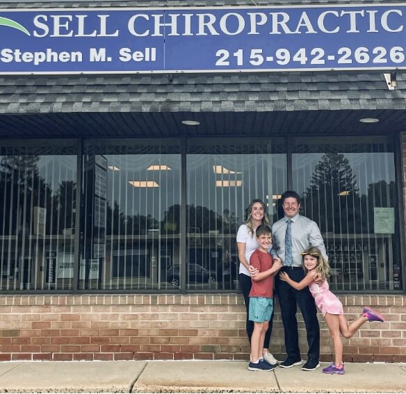 Feasterville chiropractor Dr. Sell and his family standing in front of office entrance