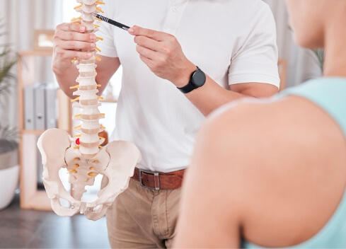 Chiropractor pointing at spine model