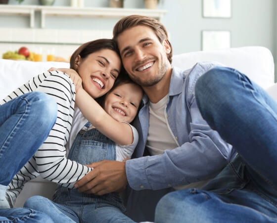 family of three sitting on couch together