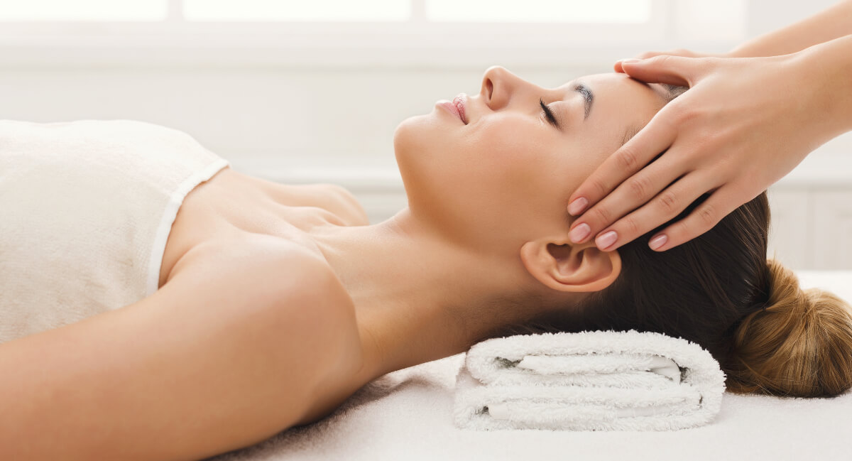 Massage therapist massaging woman's head