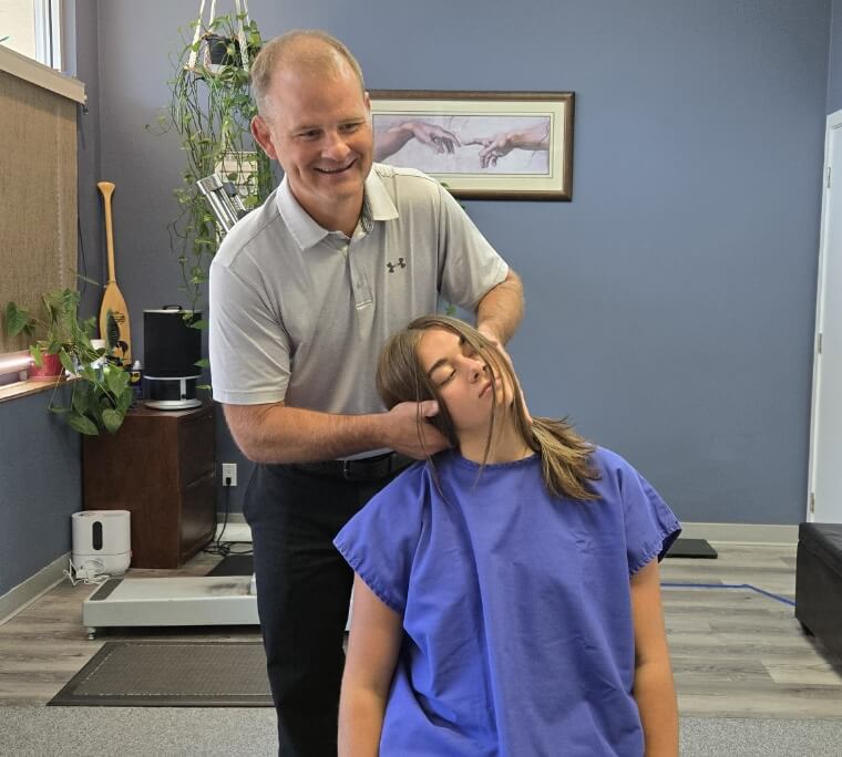 Prince George chiropractor adjusting female patient's neck