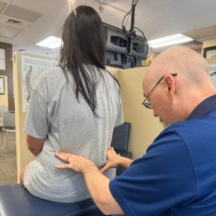 50th Street Chiropractic Chiropractor Dr. Warren checking woman's lower back