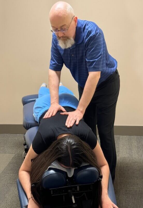 Chiropractor pressing on patient's back