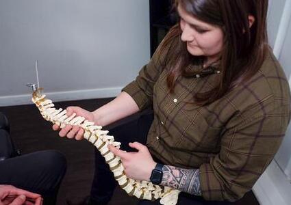 chiropractor, Meghan, explaining chiropractic with a spine