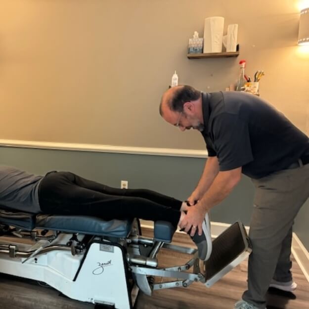 Peachtree City chiropractor adjusting patient's legs