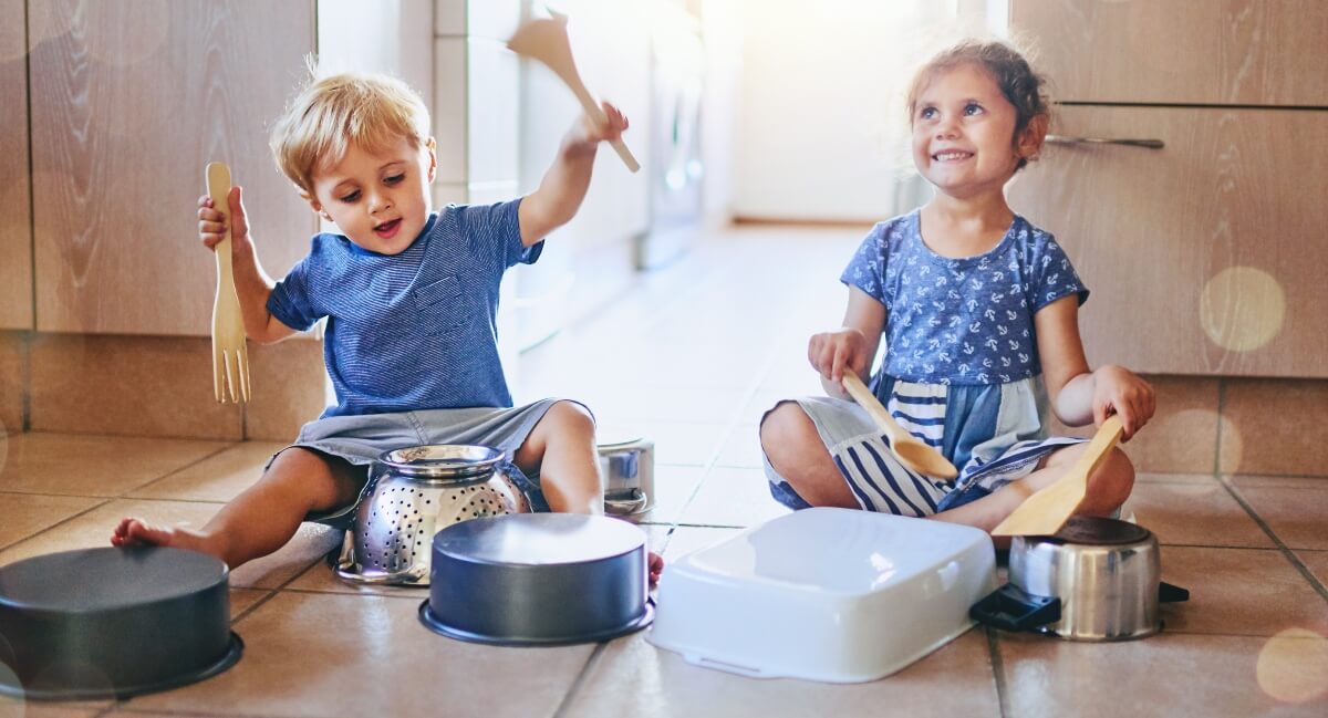 Kids on kitchen floor improvising instruments