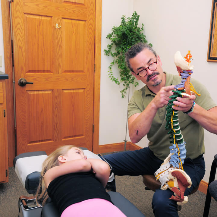 Dr. Joshua explaining spine model to a girl