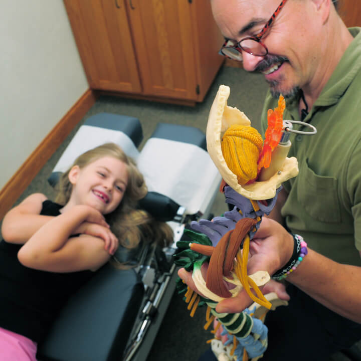Chiropractor talking to kid patient