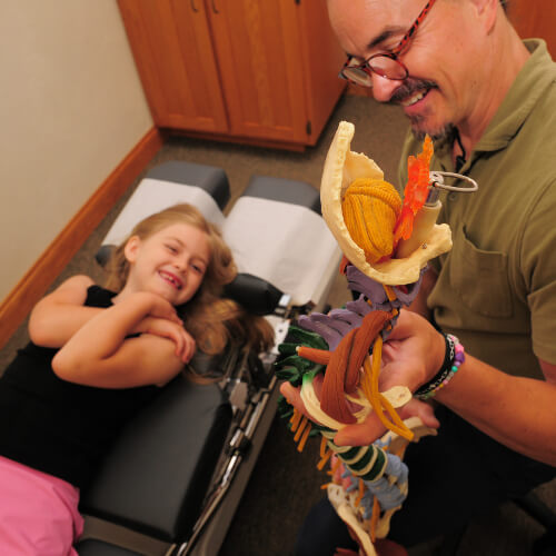 Chiropractor in a consultation with a pediatric patient