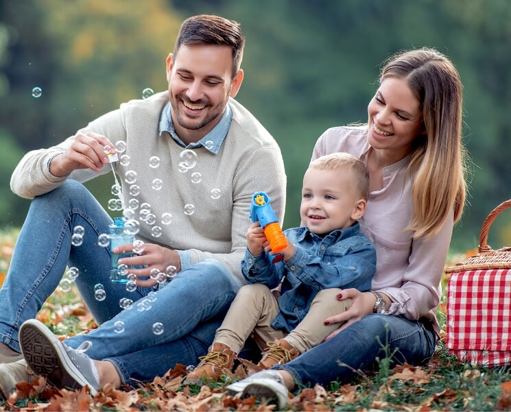 family of three playing bubbles