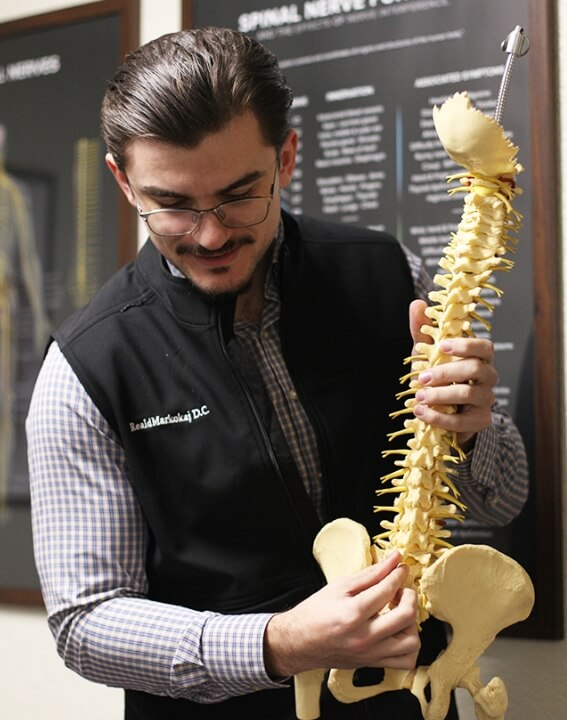 r. Reald Markokaj holding spine model