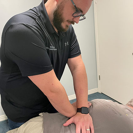 Dr Alex adjusting a patient's back