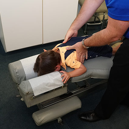 chiropractor adjusting a child