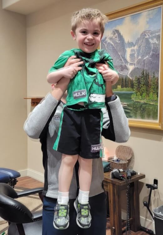 Chiropractor holding up happy child