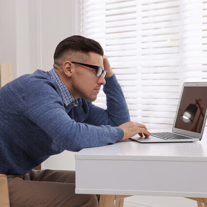 man-blue-sweater-looking-bored-at-desk-sq