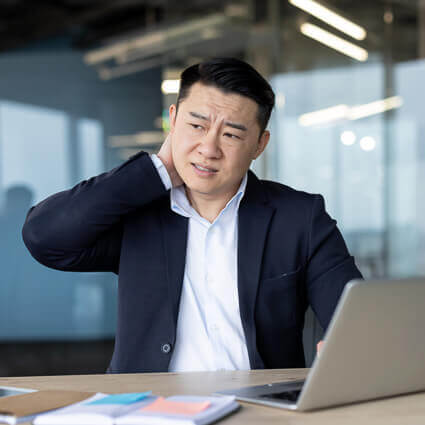 man-in-modern-office-with-neck-pain-at-desk-sq