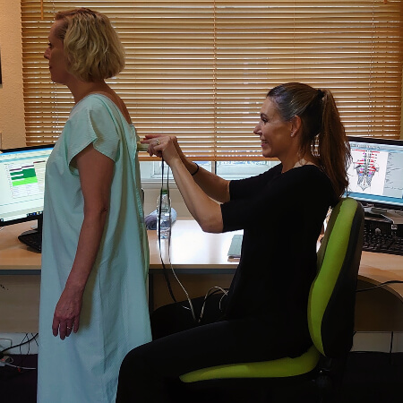 Hexham chiropractor Belinda assessing patient with instrument