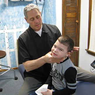 Dr. Karas adjusting a child patient