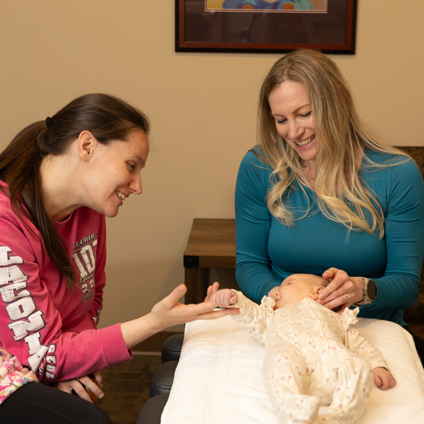 mom sitting with baby who is getting adjusted