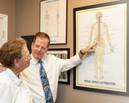 Timonium chiropractor Dr. Adolph explaining a chiropractic chart to a patient