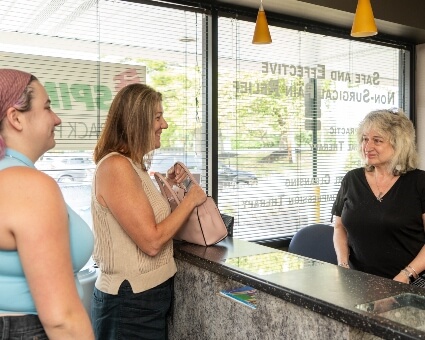 SPINALife reception staff interacting with Timonium patient