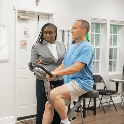 Laurel chiropractor Dr Levi assisting patient with physiotherapy