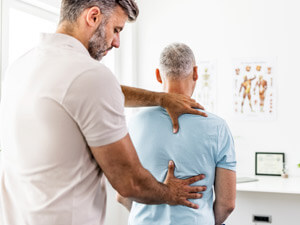 chiropractor checking patients back