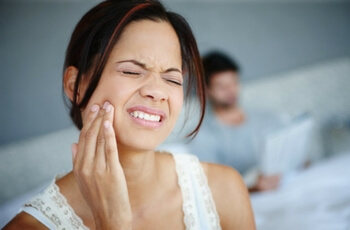 Woman touching jaw in pain.