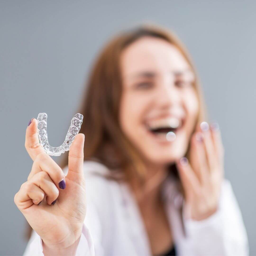 Woman holding a clear aligner.