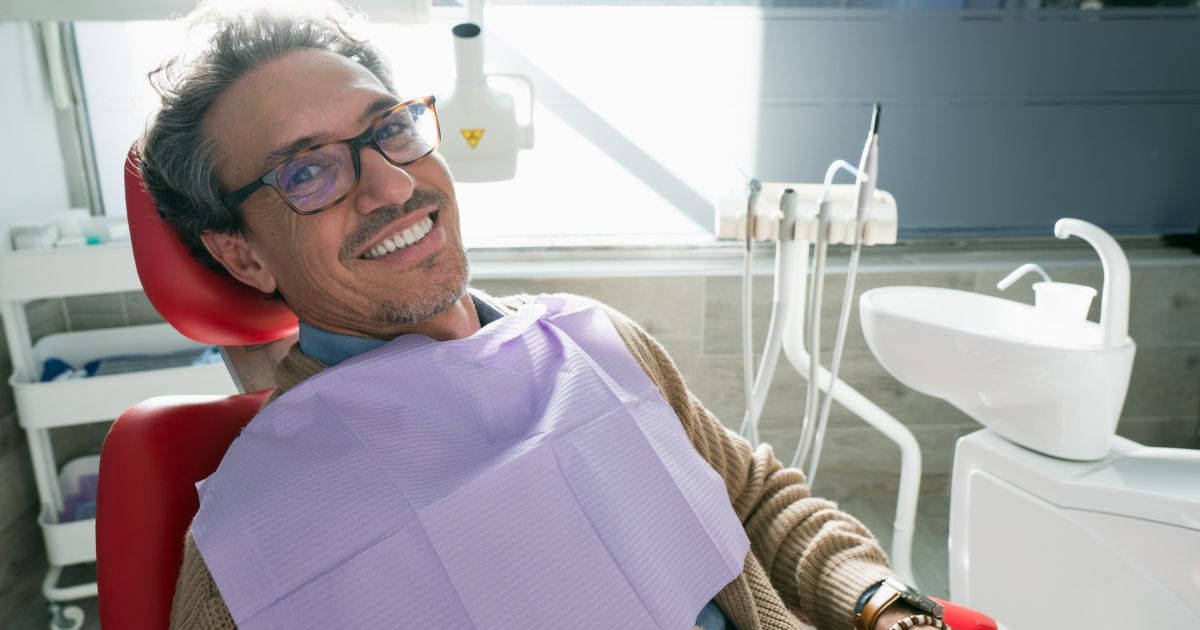 Man in dental chair smiling.