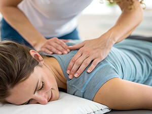woman laying down having shoulder examined