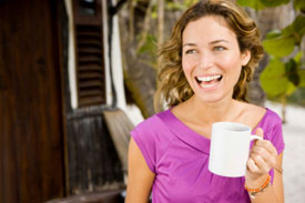Woman smiling holding a coffee cup