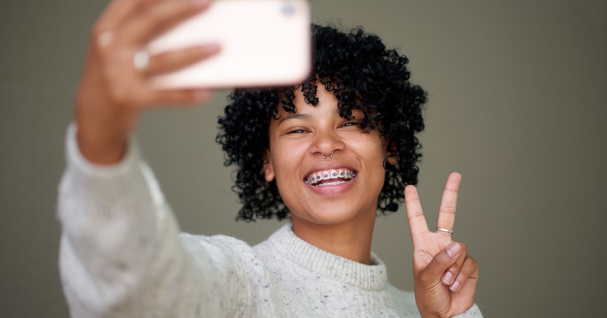 Woman with braces taking a selfie.