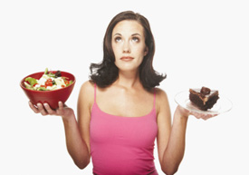Woman deciding between a salad and piece of cake