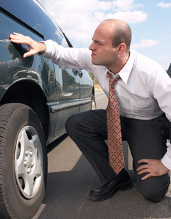 Man looking at scratched car