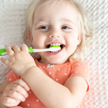 baby girl with toothbrush