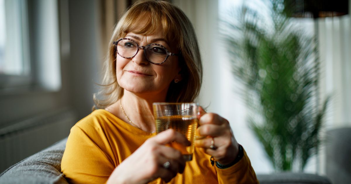 Woman smiling drinking green tea.