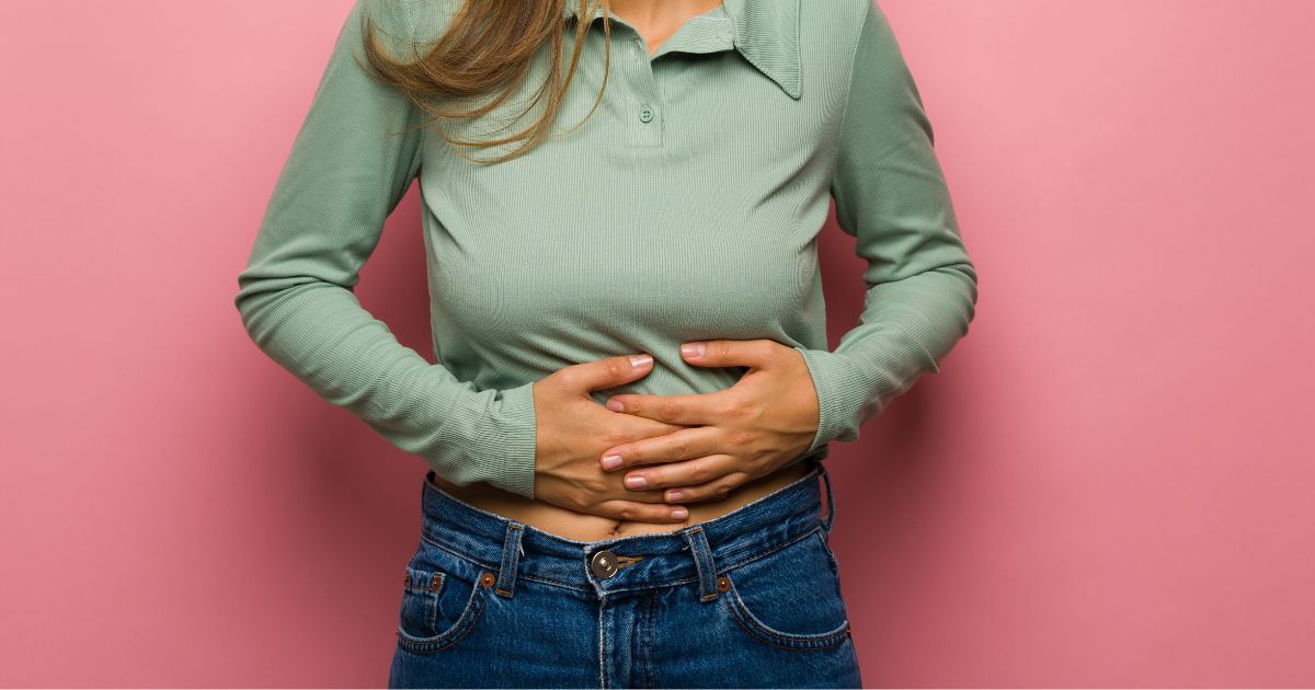 Woman holding stomach.