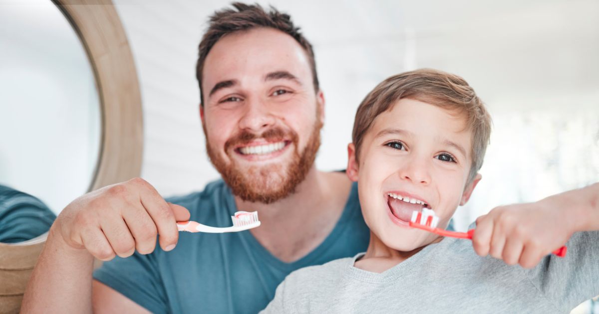Father and son brushing teeth.