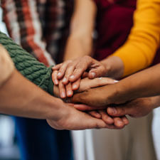 people with their hands in the middle of a circle