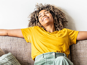 woman on a couch smiling and breathing easy