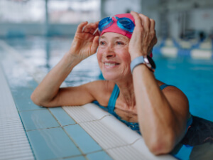 woman at swimming pool taking off goggles