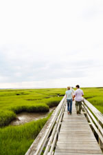 Two people walking up a dock at the creek