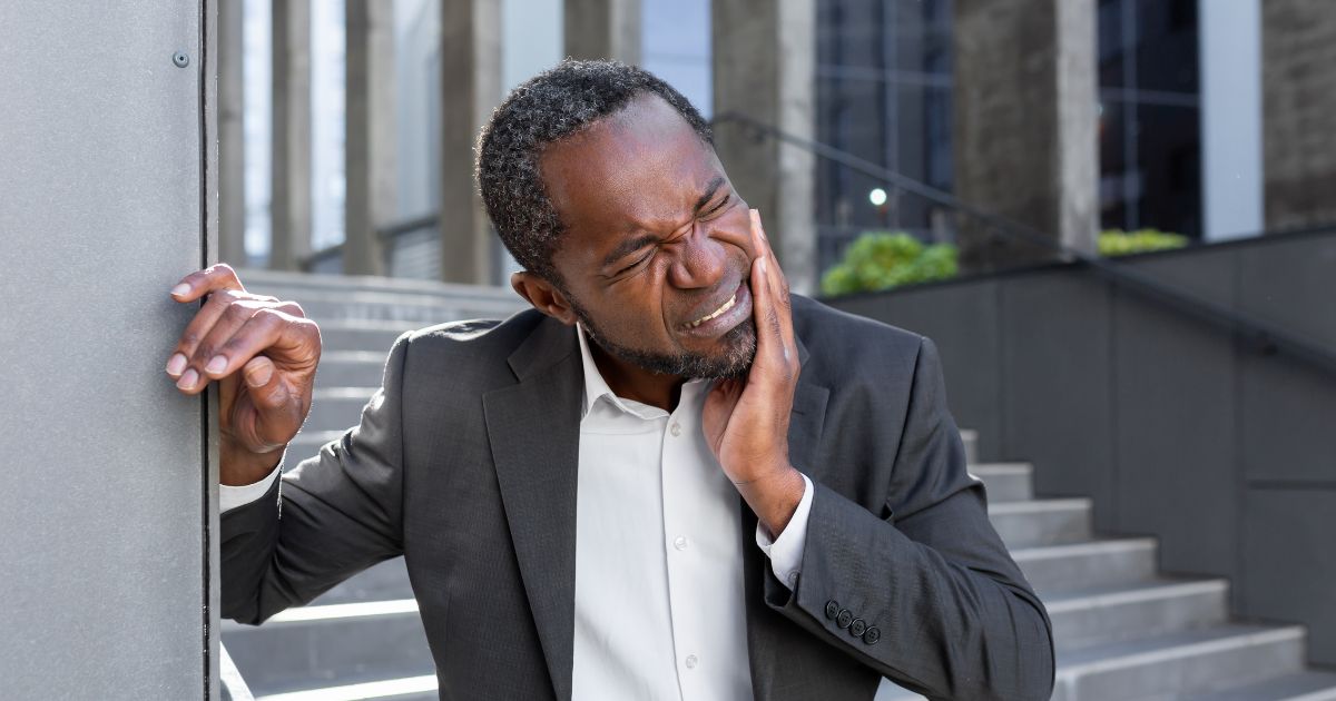 Man grabbing jaw in pain.