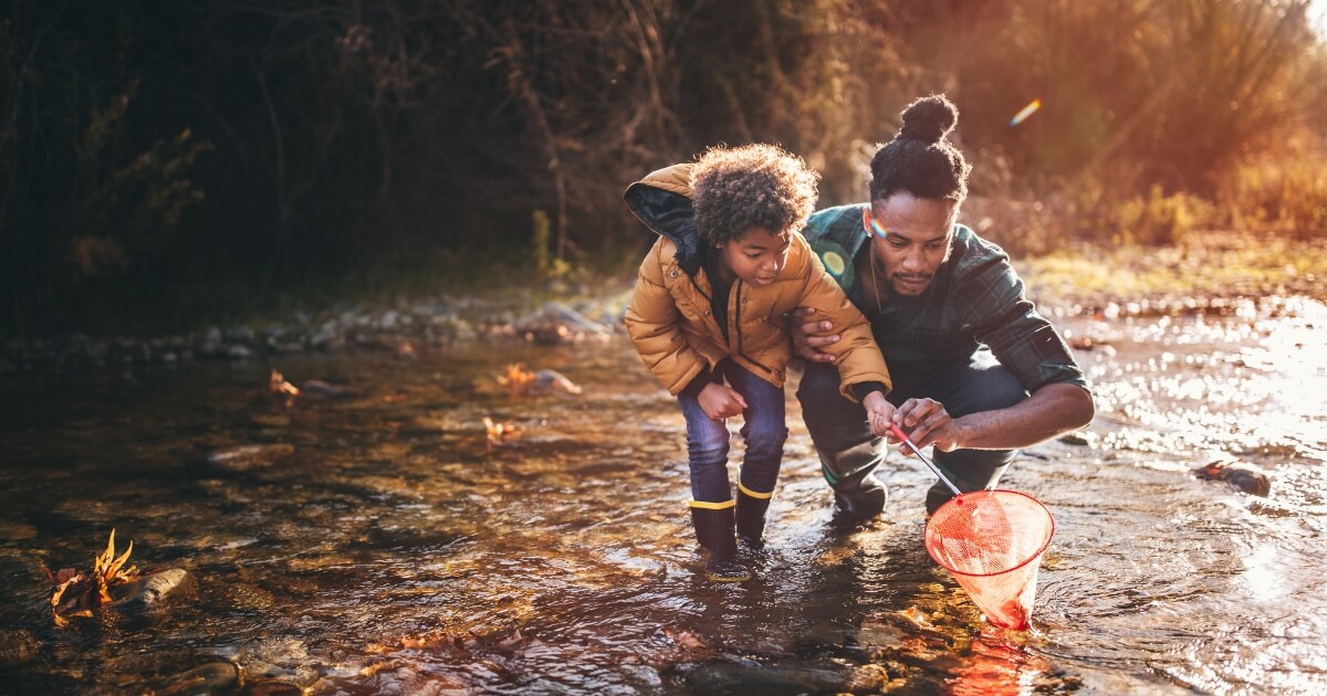 Father and son playing in a stream.