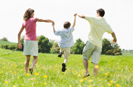 Family running through a grassy field