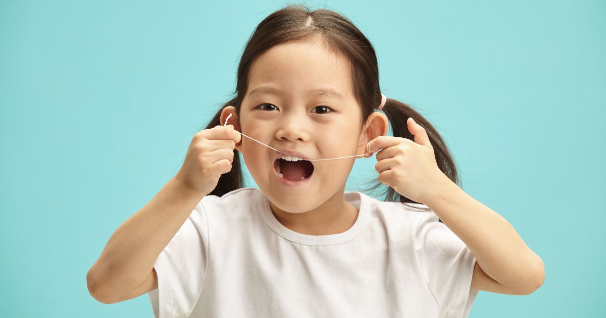 Little girl flossing.