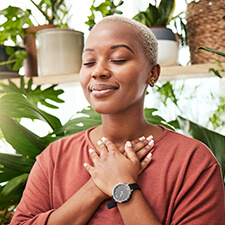 smiling woman with her hands on her chest