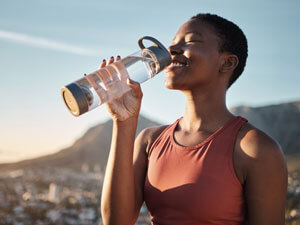 happy woman drinking water outside